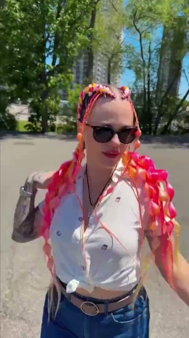 Neon coral and pink braids finished with beads, worn outdoors